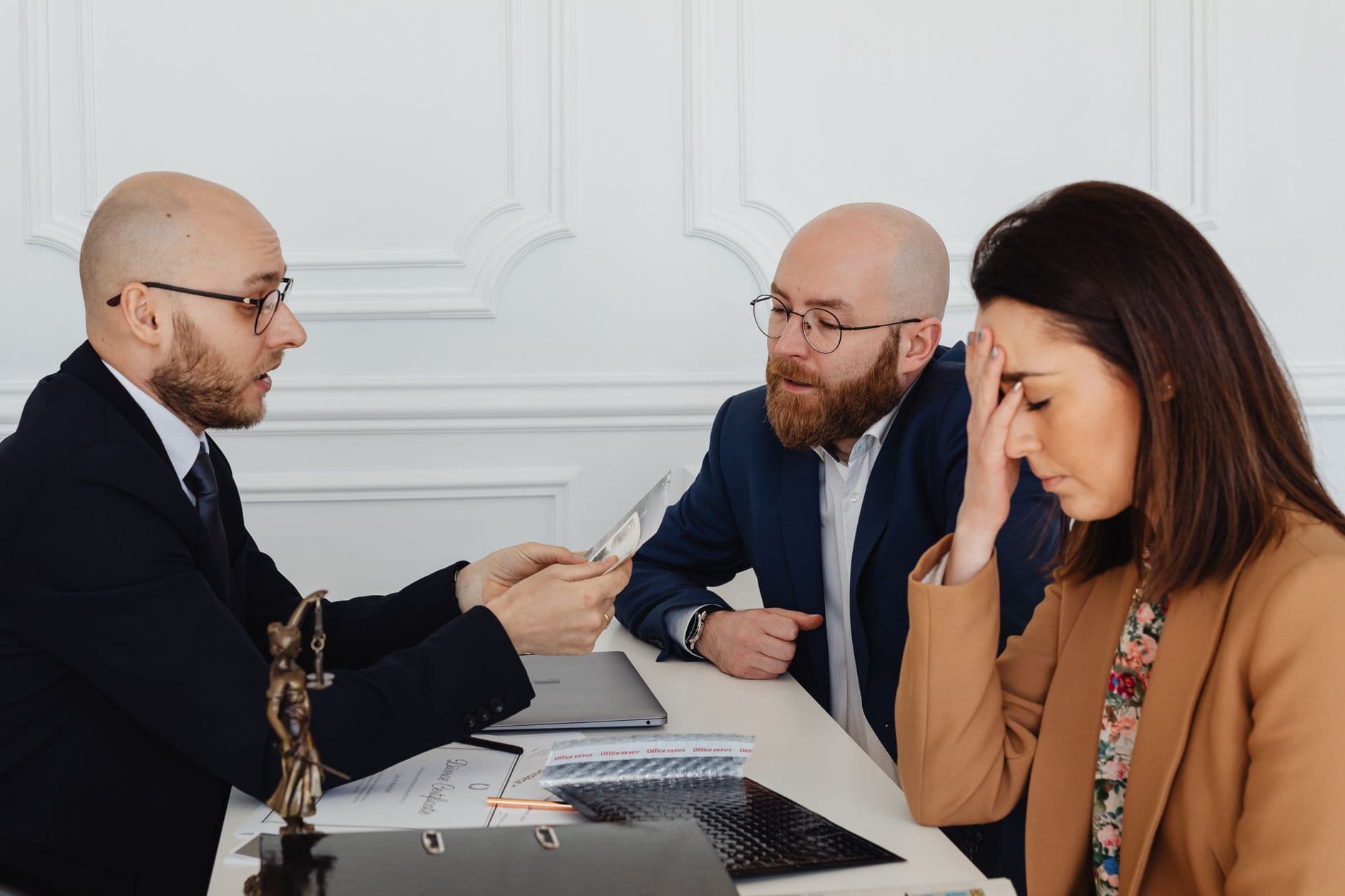 Avocat et couple en discussion autour d'un divorce à l'amiable dans un cabinet.
