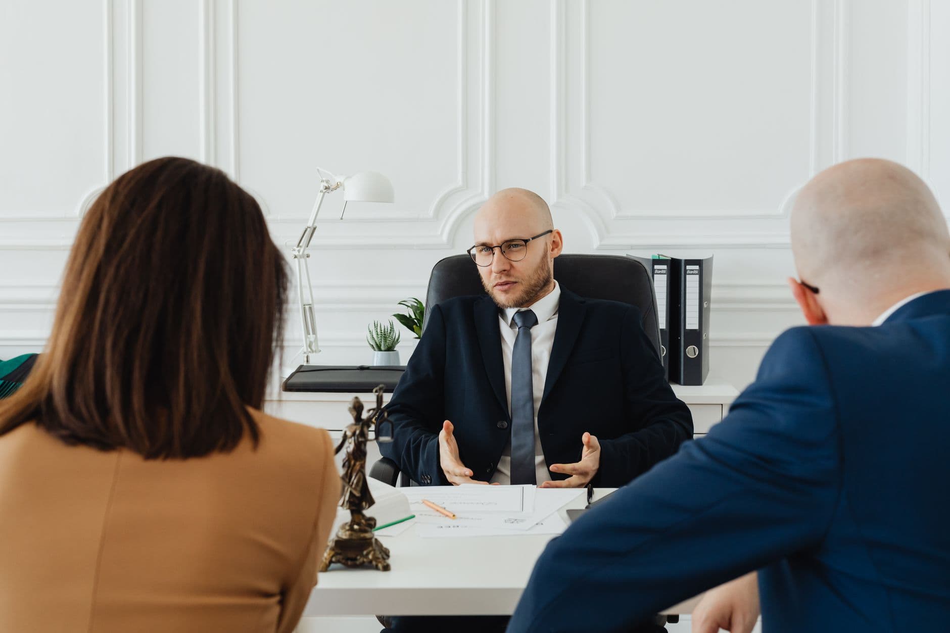 Un couple consulte des documents immobiliers sur le logement lors d'un divorce, dans un cabinet.